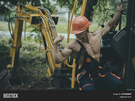 Sexy Man With Nude Torso Near Construction Equipment Or Excavator On Background Sexy Builder