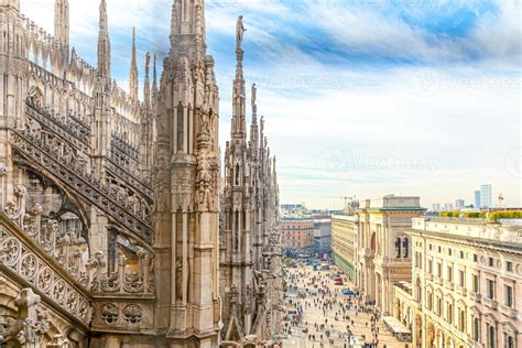 Roof of Milan Cathedral Duomo di Milano with Gothic spires and white marble statues. Top tourist ...