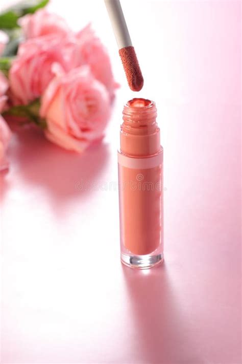 Nude Beige Lip Gloss In Tube With Roses On Background Cosmetic Make Up Concept Stock Photo
