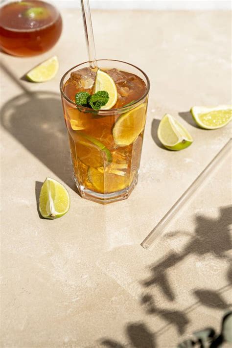 Iced Tea With Lemon Fresh Mint Leaves And Ice In Tall Glasses With Sun