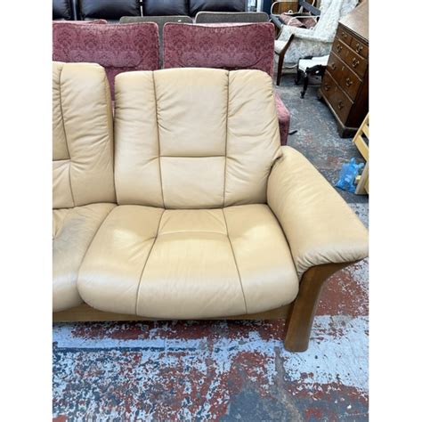 An Ekornes Stressless Tan Leather And Beech Reclining Two Seater Sofa