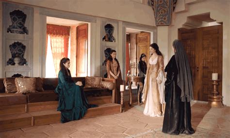 Three Women In Dresses Are Sitting On Couches And One Woman Is Standing