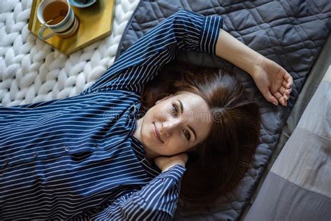 Top View Portrait Of Happy Relaxed Domestic Woman In Pajamas Lying On