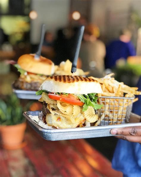 two trays with sandwiches and fries on them