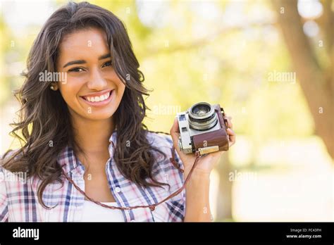 Pretty Brunette In The Park Using Retro Camera Stock Photo Alamy