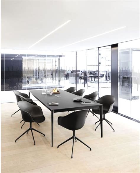 An Empty Conference Room With Black Chairs And A Long Table In Front Of