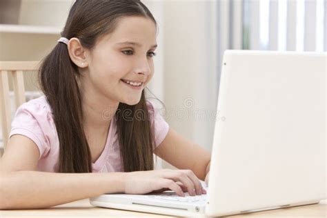 Crian A Da Menina Que Usa O Computador Port Til Em Casa Imagem De Stock