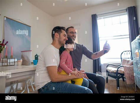 Gay Fathers And Adopted Daughter Talking Selfie With Smart Phone Stock