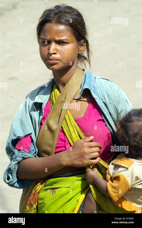 Portrait of young female beggar holding her alleged child at streets of ...