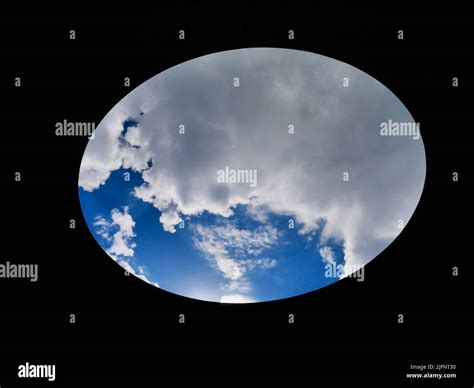 Blue sky with clouds seen through oval hole Stock Photo - Alamy