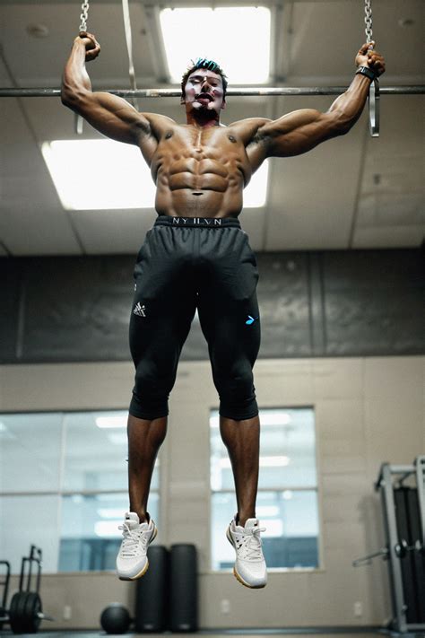 Masculine man doing pull-ups in the gym, showcasing upper body strength