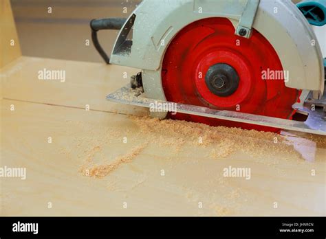 Carpenter Using Circular Saw Cutting Wooden Board In Wood Workshop