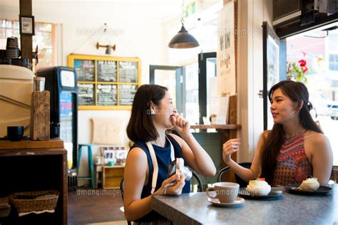 カフェで笑っている女性二人 10568004869 の写真素材・イラスト素材｜アマナイメージズ