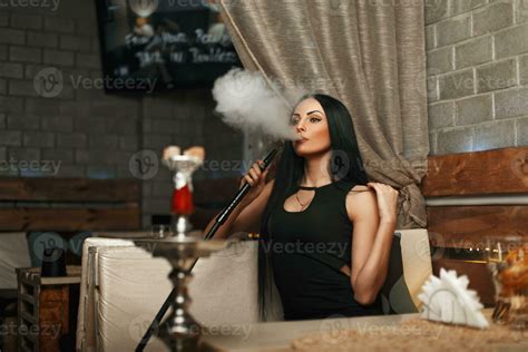 The Beautiful Girl Smokes A Hookah And Lets The Smoke Woman Resting In