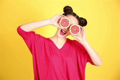 Hermosa Mujer Joven Con Mitades De Pomelo Cerca De Los Ojos Sobre Fondo