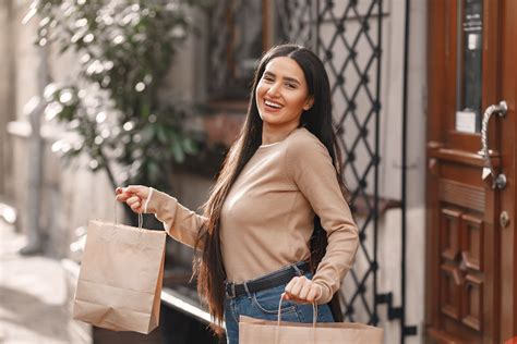 Joyful Multiethnic Adult Couple With Shopping Bags Walking Along Street