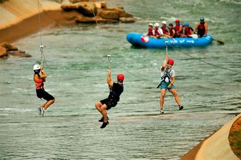 High adventurers zipline through the air at the US National Whitewater Center in Charlotte, NC ...