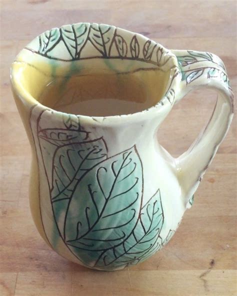 A Green And White Vase Sitting On Top Of A Wooden Table