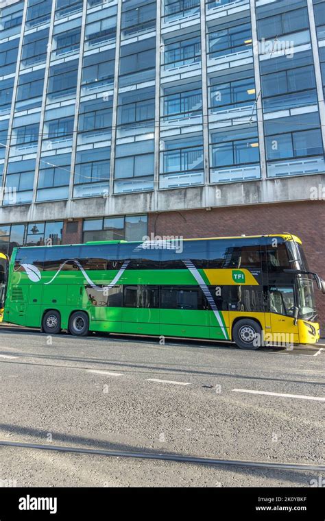 A Vertical Shot Of A Green And Yellow Double Deck Bus And A Glass