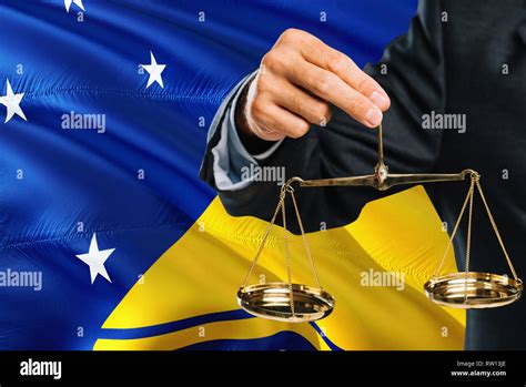 Judge Is Holding Golden Scales Of Justice With Tokelau Waving Flag