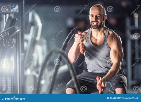 Muscular Man Exercising With Battle Ropes At The Fitness Gym Stock