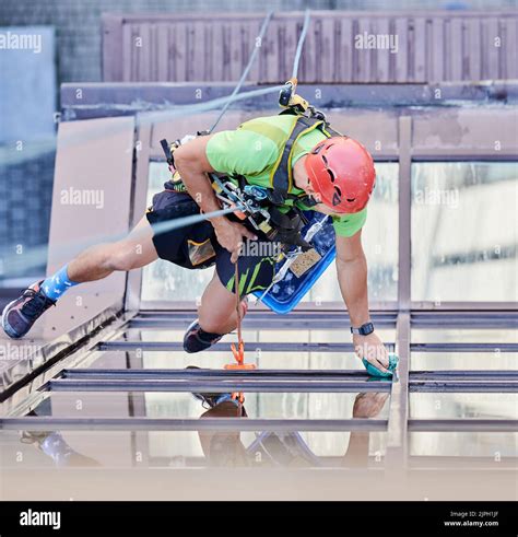 Industrial Mountaineering Worker Washing Glass Windows Of High Rise