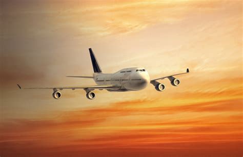 Airplane Flying In The Orange Sky At Sunrise Stock Photo Download