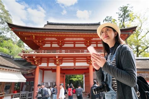 Uma Viajante Feminina Elegante Usando Seu Telefone Celular Em Frente