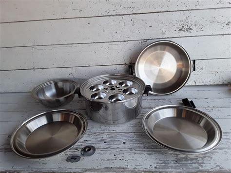 A Group Of Metal Bowls Sitting On Top Of A White Wooden Floor Next To Each Other