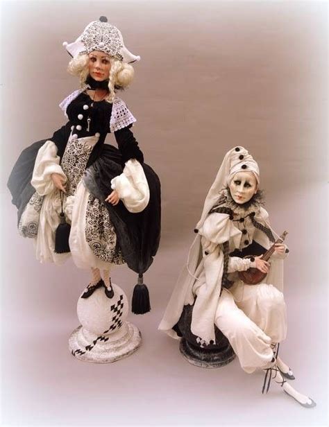 Two Dolls Dressed In Black And White Sitting Next To Each Other