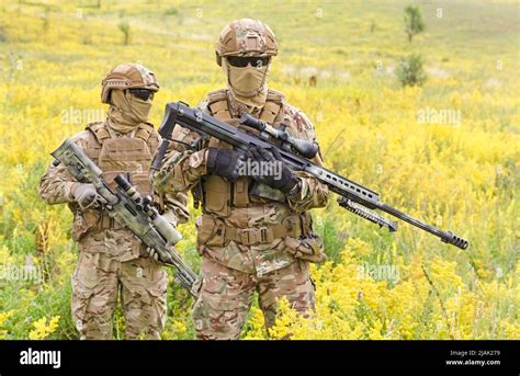 Two Armed Special Forces Soldiers With Sniper Rifles Standing In A