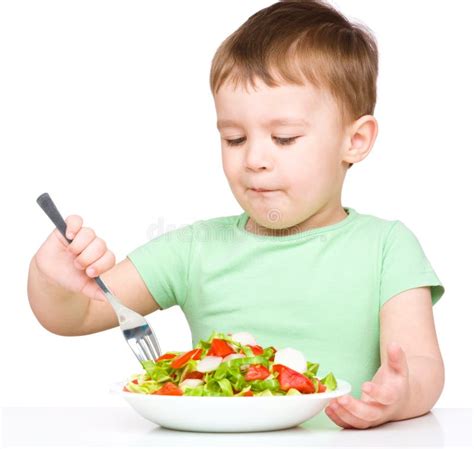 El Niño Pequeño Lindo Está Comiendo La Ensalada Vegetal Foto De Archivo