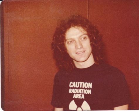 A Man With Curly Hair Wearing A T Shirt That Says Caution Radiation Area