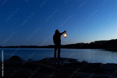 Man Holding The Old Lamp Outdoors Near The Lake Hand Holds A Large