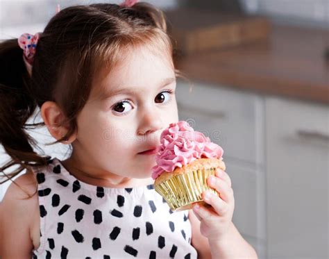 Cute Little Girl Holding Birthday Cupcakes In Kitchen Stock Photo