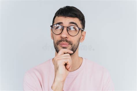 Horizontal Portrait Of Handsome Pensive Male Keeps Hand Under Chin