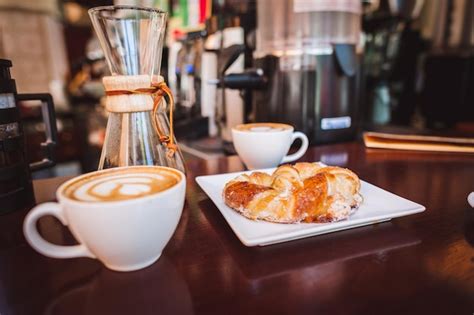 Premium Photo Close Up Of Cappuccinos And Croissant Served On Table