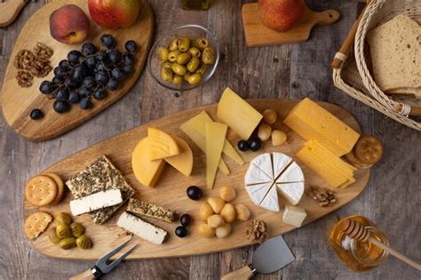 Premium Photo | Cheese platter on a wooden board several sliced cheeses ...