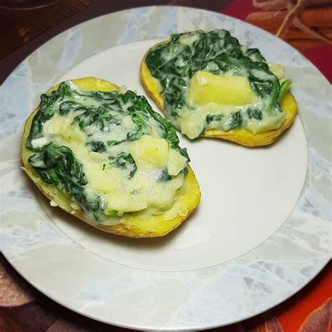 Two Pieces Of Bread With Spinach And Cheese On It Sitting On A Plate