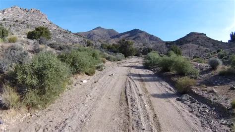 Off-road driving up steep and rough high-desert mountain trails. POV ...