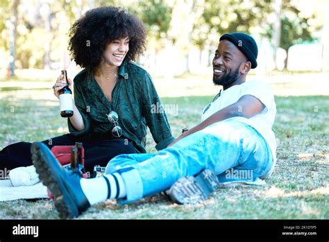 Interracial Couple In Nature Park Together Man And Woman Relax With Drink On Grass And