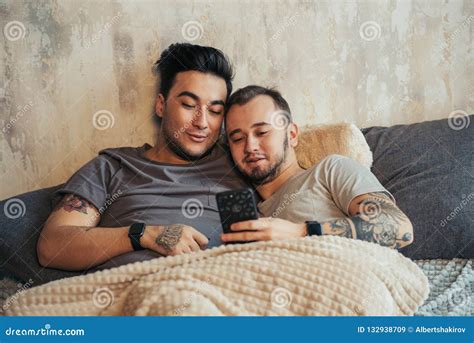 Coppie Gay Felici Che Prendono Selfie Sul Letto A Casa Immagine Stock