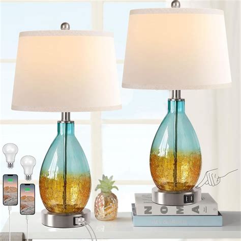 two lamps on a table with pineapples and other items in front of them