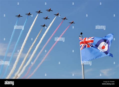 RAF, Royal Air Force Red Arrows jet planes flying over RAF ensign flag ...