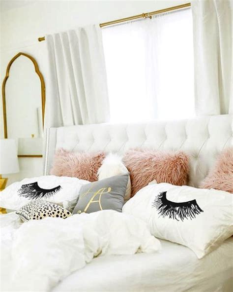 A White Bed With Pink Pillows And Eye Lashes On The Pillowcase In