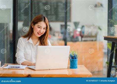 Pretty Smiling Asian Female Accountant Working On Laptop Computer In