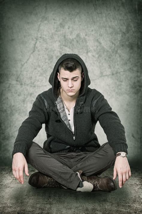 Hombre Joven Que Se Sienta En El Piso Y El Aprendizaje Foto De Archivo