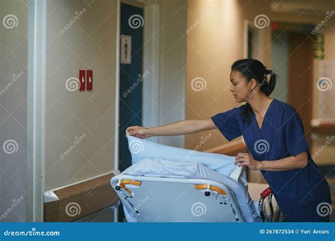 Prepping The Hospital Bed A Female Nurse Making Up A Hospital Bed