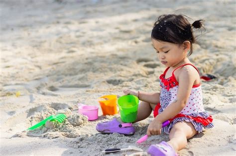 Premium Photo Happy Asian Child Girl Playing Sand On The Beach At The