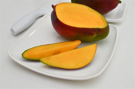 Premium Photo A Closeup View Of A Sliced Ripe Yellow Mango On A White